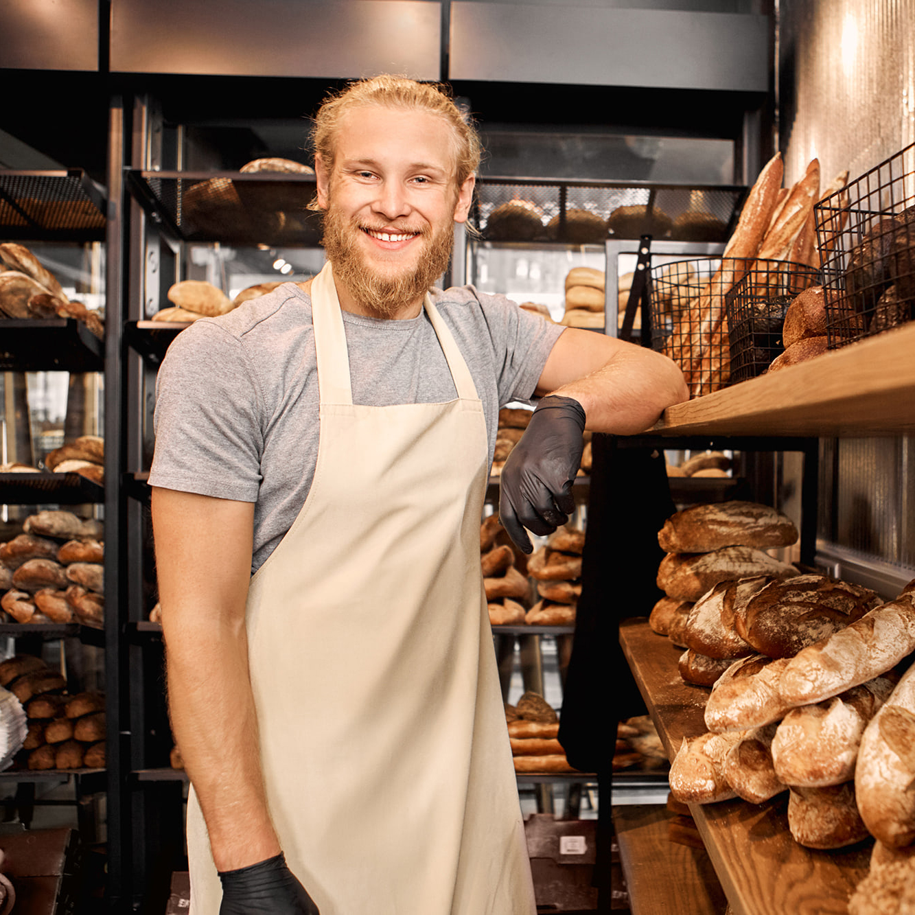 Baker next to shelves of bread